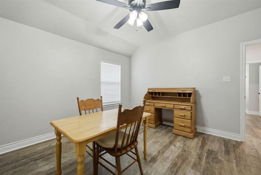 Dining space featuring vaulted ceiling, dark wood finished floors, and ceiling fan