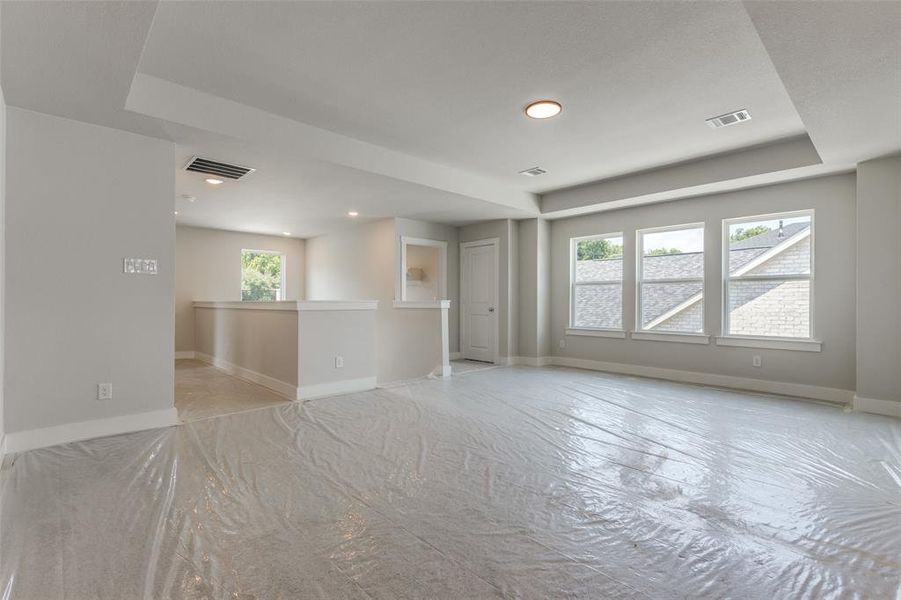 Unfurnished living room with a tray ceiling