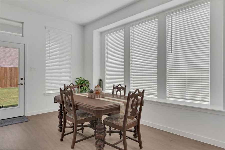 Dining space featuring light wood-style flooring and baseboards