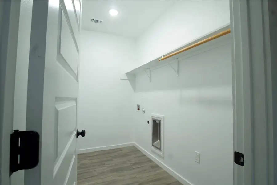 Washroom with light wood-type flooring, hookup for a washing machine, and hookup for an electric dryer