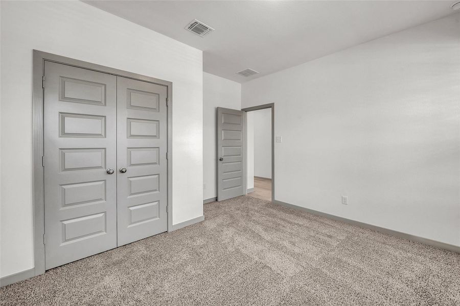 Unfurnished bedroom featuring carpet and a closet