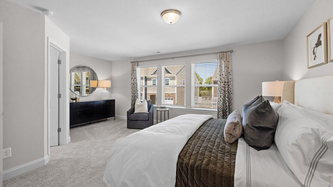 Primary bedroom with extra space, seating area, and large walk-in closet in the Rochester Design by DRB Homes Charlotte, NC Primary bedroom with extra space, seating area, and large walk-in closet in the Rochester Design by DRB Homes Charlotte, NC