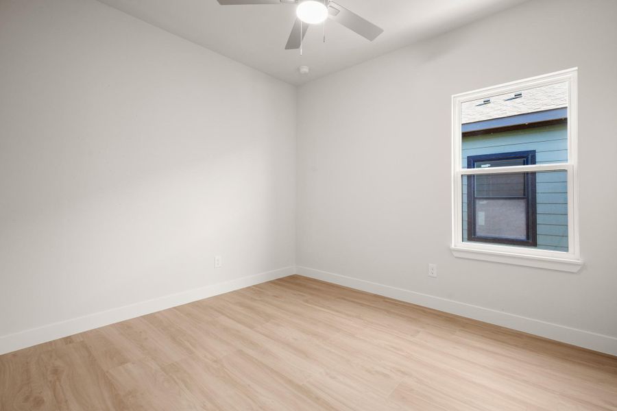 Empty room featuring light wood-type flooring and a ceiling fan