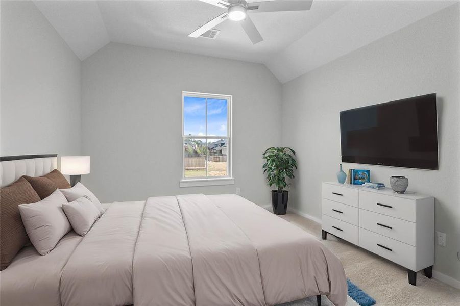 Secondary bedroom features plush carpet, custom paint, ceiling fan with lighting and a large window with privacy blinds.