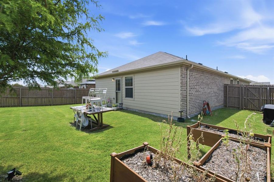 Large backyard with raised garden beds and six foot privacy fence of 1028 Naranjos Dr, Haslet TX in Rancho Canyon