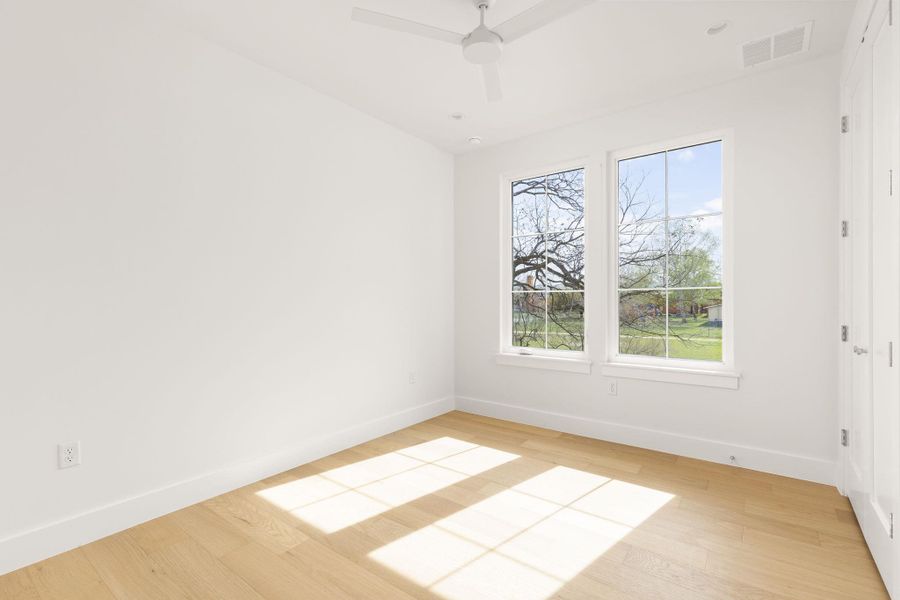 Unfurnished room with light wood-type flooring and a ceiling fan Unfurnished room with light wood-type flooring and a ceiling fan