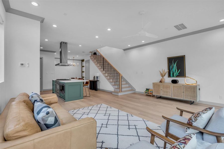 This view showcases the living room and kitchen areas, with the staircase leading to the second floor visible in the background.