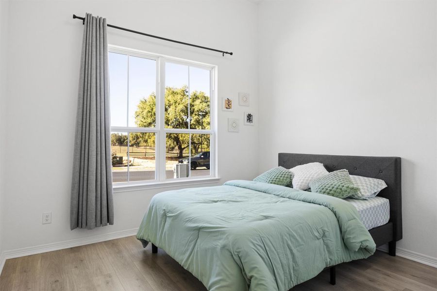 Bedroom with wood finished floors and baseboards Bedroom with wood finished floors and baseboards