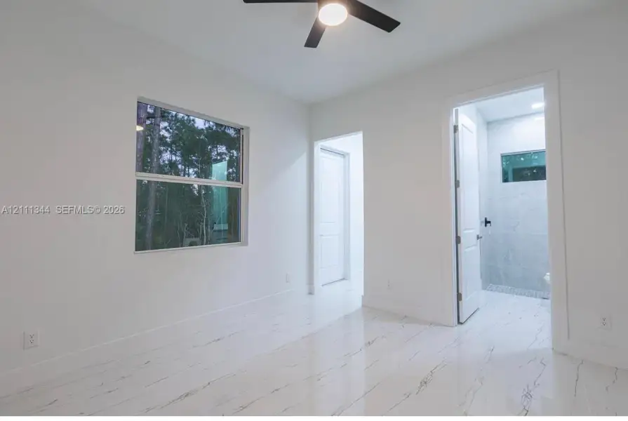 Polished stone-finish flooring, matte black ceiling fan with integrated lighting, and high-contrast dual-pane window Polished stone-finish flooring, matte black ceiling fan with integrated lighting, and high-contrast dual-pane window