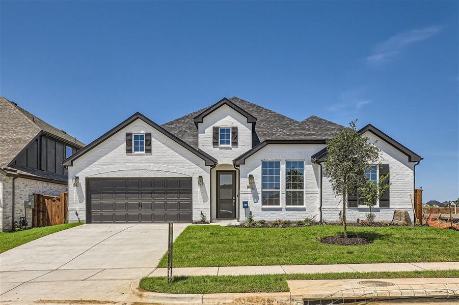 View of front of property featuring a garage and a front yard