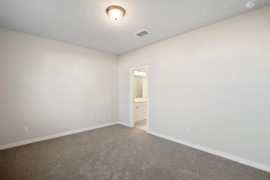 Carpeted spare room featuring baseboards