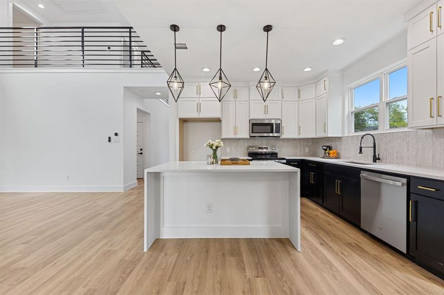 The property features a kitchen with a spacious island, two-tone cabinetry, and stainless steel appliances The property features a kitchen with a spacious island, two-tone cabinetry, and stainless steel appliances