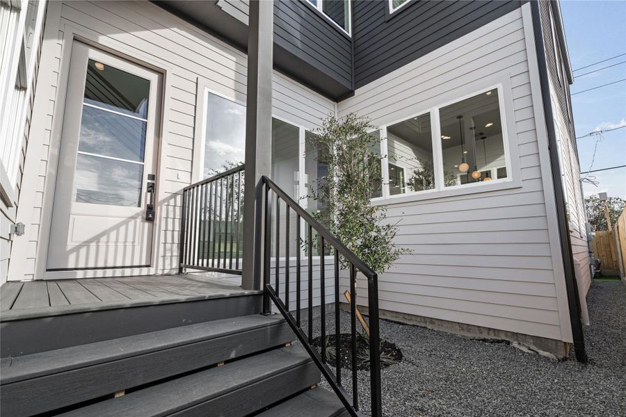 A quiet moment before you step inside—clean-lined siding, steel railings, and curated landscaping set a tone of understated refinement. Every detail of the entry feels intentional and inviting.