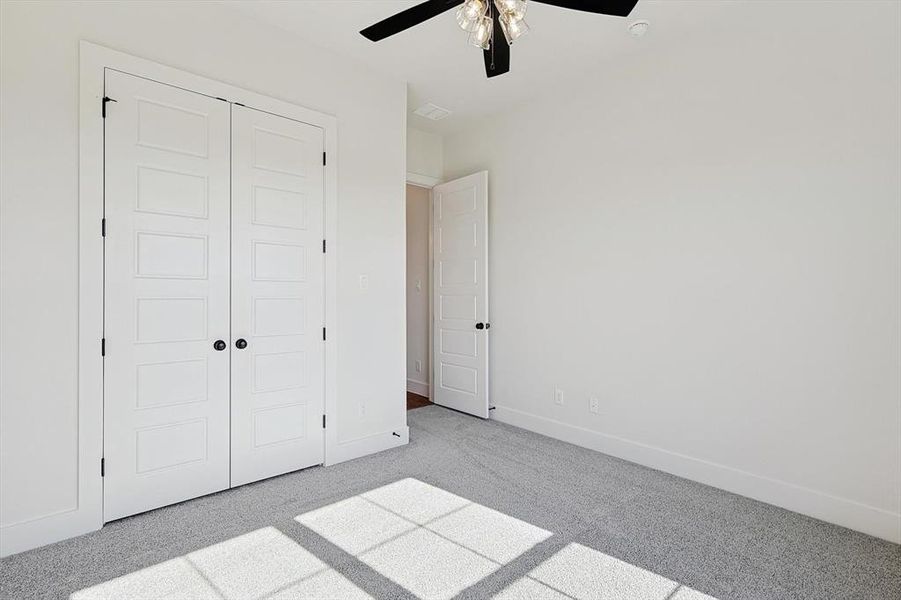 Unfurnished bedroom featuring light carpet, a closet, and ceiling fan