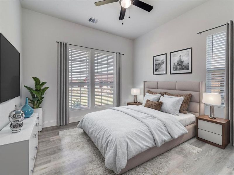 Bedroom with light wood-style floors, multiple windows, and a ceiling fan Bedroom with light wood-style floors, multiple windows, and a ceiling fan