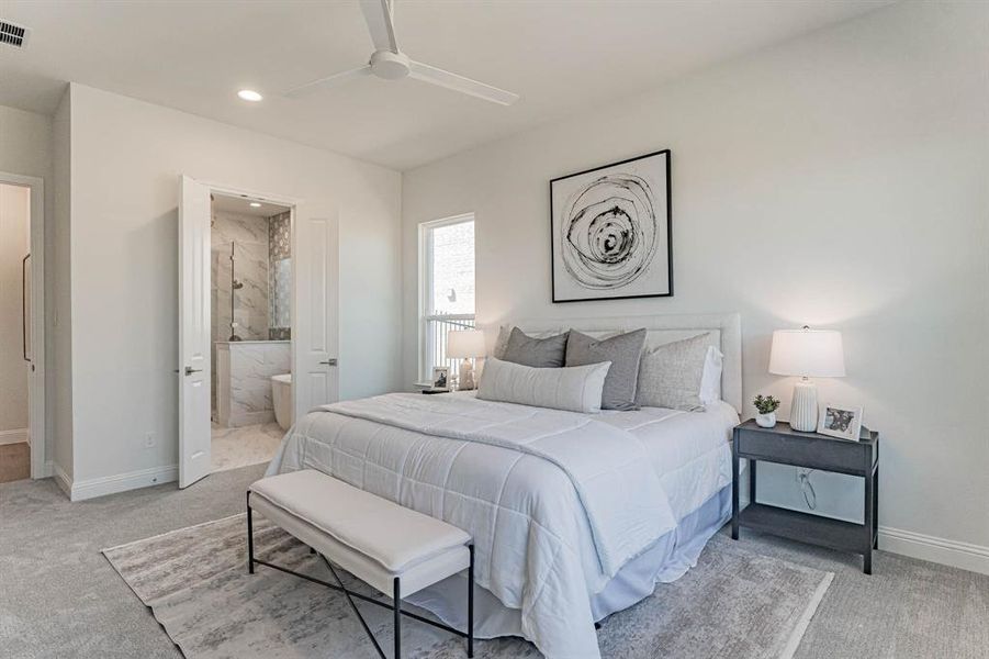 Carpeted bedroom with ensuite bath and ceiling fan