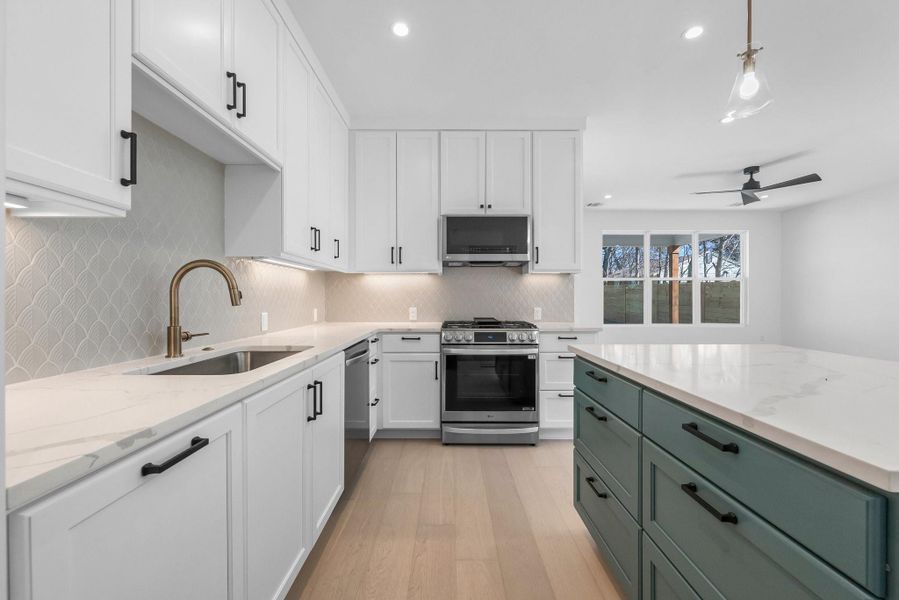 This modern kitchen offers a gas range, microhood, pantry, and corian countertops.