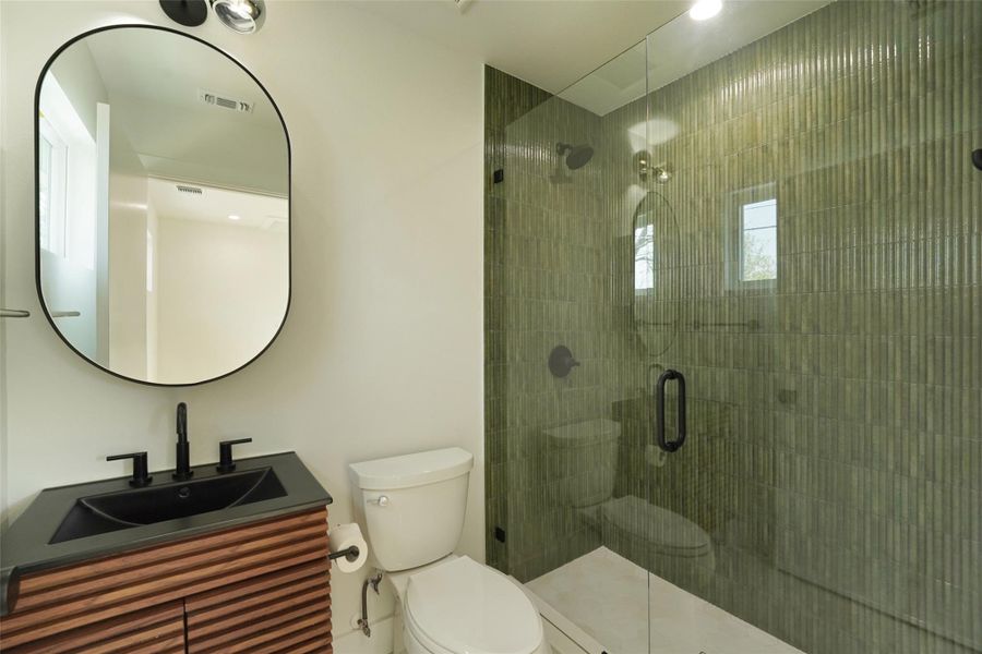 Full bath featuring toilet, a shower stall, and vanity