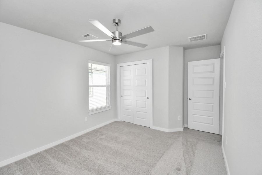 Generously sized secondary bedrooms featuring spacious closets, soft and inviting carpeting underfoot, large windows allowing plenty of natural light, and the added touch of privacy blinds for your personal retreat. Sample photo of completed home with similar floor plan. Actual colors and selections may vary.