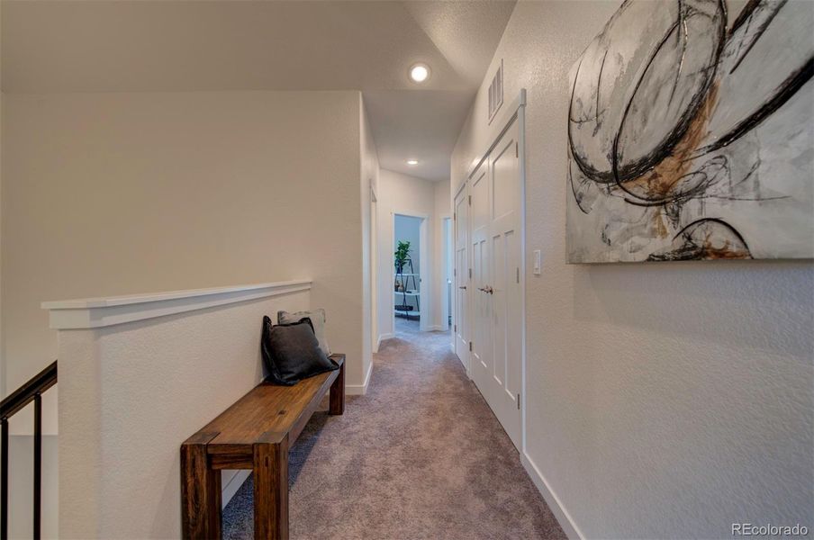 Hallway looking from the primary bedroom and stairs towards the other two bedrooms.