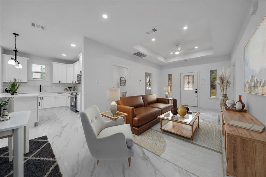 Living room featuring ceiling fan and a tray ceiling