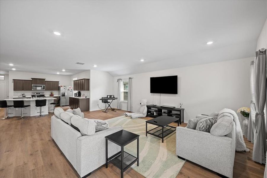 Living room with light wood finished floors and recessed lighting Living room with light wood finished floors and recessed lighting