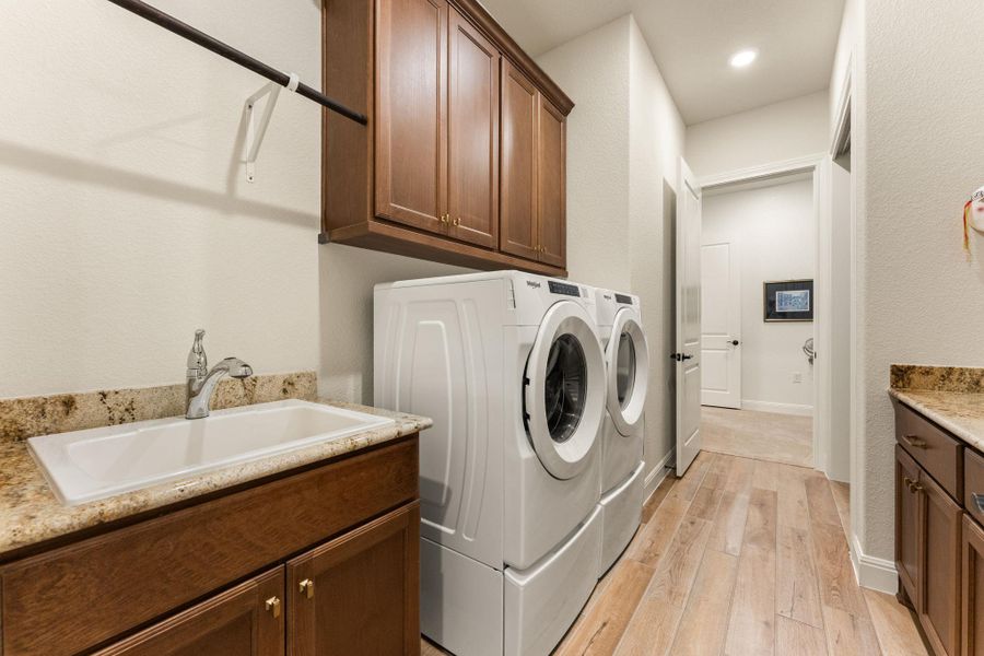 The spacious laundry room features excellent storage and counter space, and offers a sink for convenience. The cabinets are American Beech-Chateau with Crescent Veil countertops. The spacious laundry room features excellent storage and counter space, and offers a sink for convenience. The cabinets are American Beech-Chateau with Crescent Veil countertops.