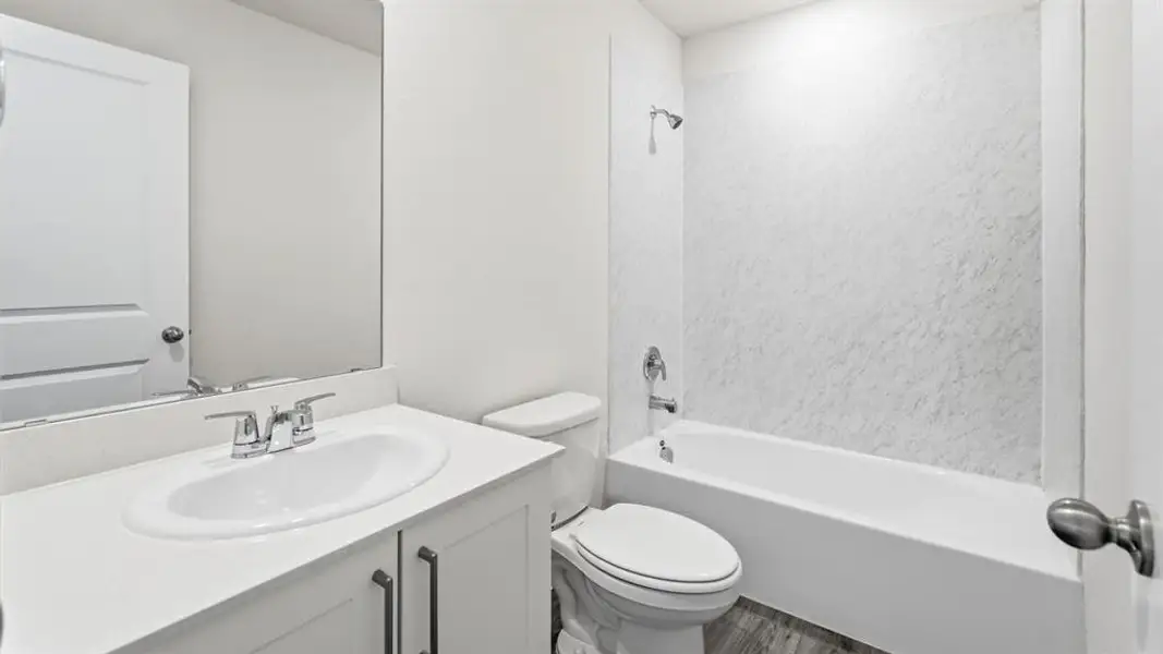 Full bathroom with vanity, shower / washtub combination, and wood finished floors Full bathroom with vanity, shower / washtub combination, and wood finished floors