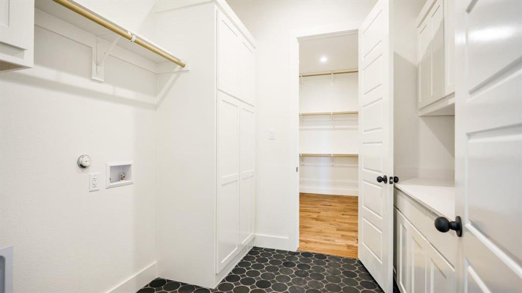 Clothes washing area with hookup for a washing machine, dark hardwood / wood-style flooring, and cabinets