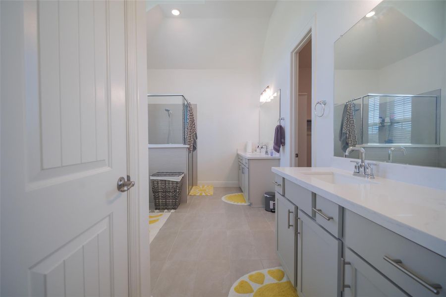 Clean lines and a spacious layout define this well-appointed bathroom with dual vanities and a walk-in shower.