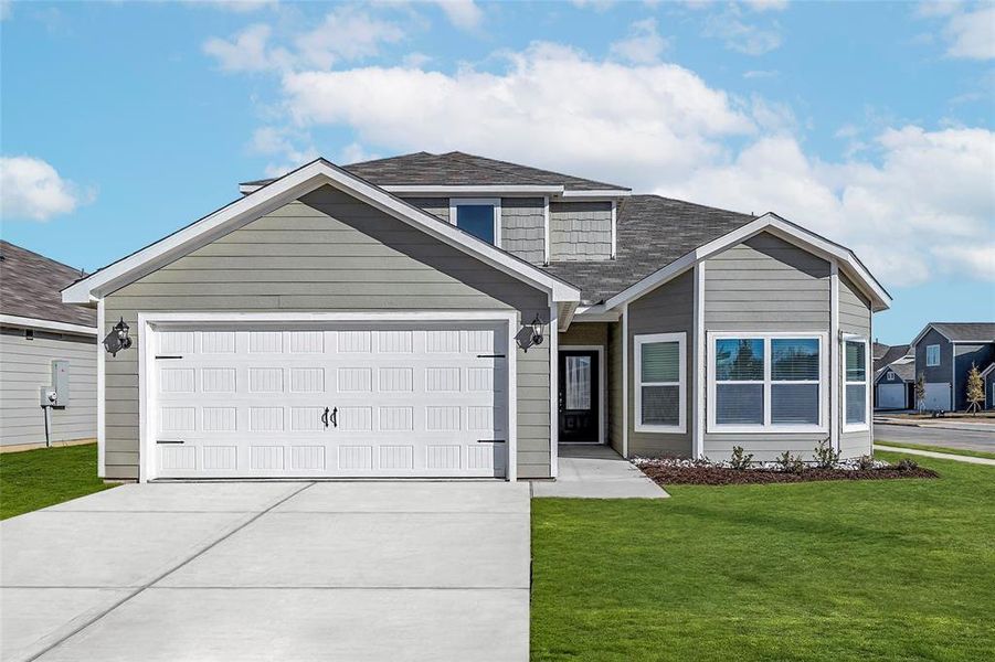 View of front of house with a garage and a front yard