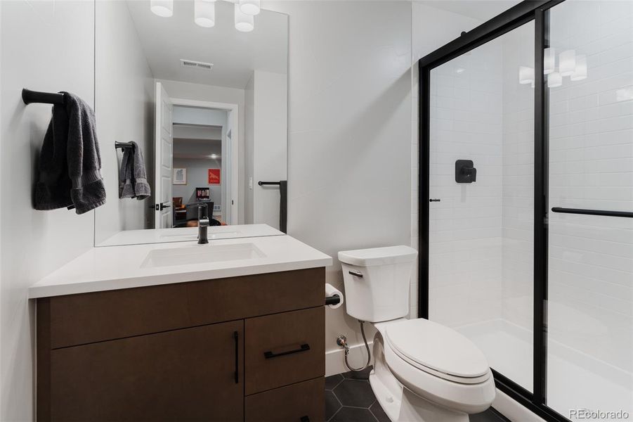 The accompanying basement bathroom, finished with high-end fixtures and sumptuous details, amplifies the sense of luxury.