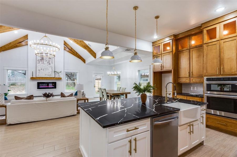 Kitchen featuring white cabinetry, an island with sink, and sink