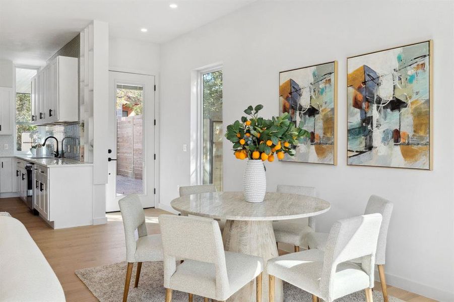Dining room featuring light wood finished floors, healthy amount of natural light, and recessed lighting