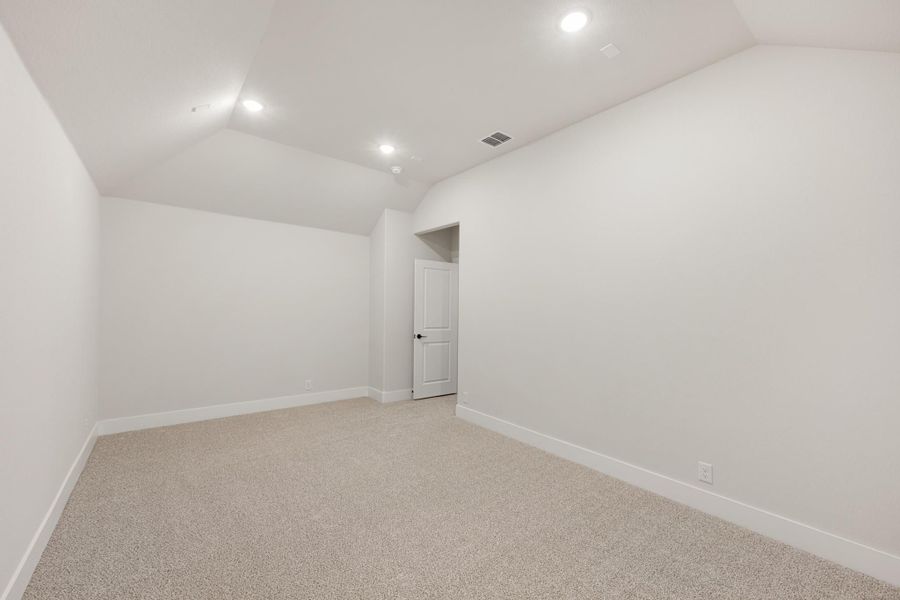 Empty room with vaulted ceiling, recessed lighting, beige carpet, and white walls