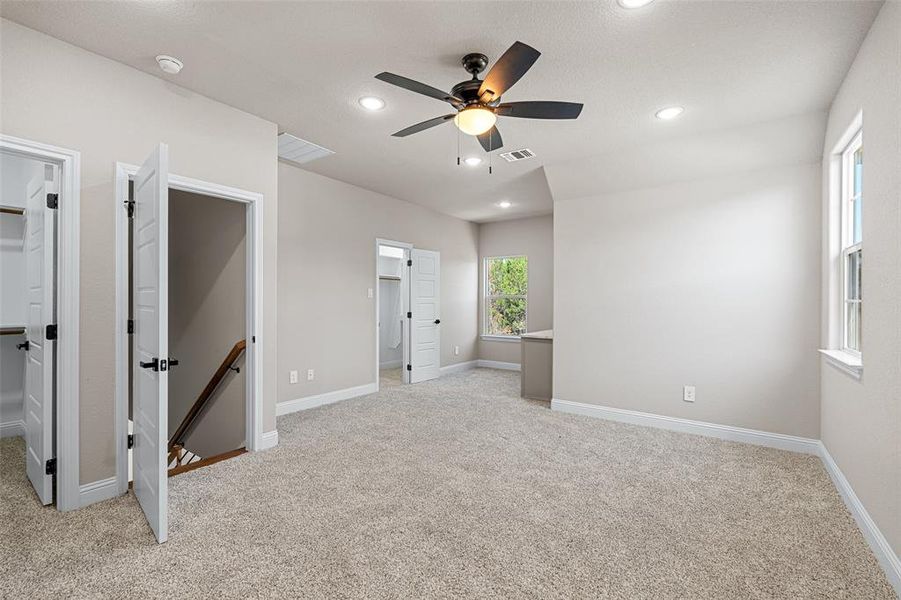 Carpeted spare room featuring ceiling fan