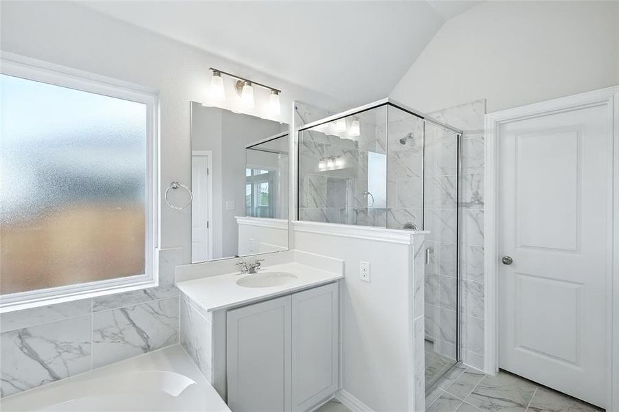 Bathroom with a marble finish shower, light marble finish floors, vanity, a bath, and vaulted ceiling Bathroom with a marble finish shower, light marble finish floors, vanity, a bath, and vaulted ceiling