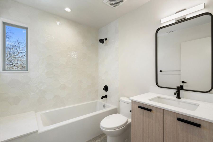 Full bath featuring toilet, shower / bathtub combination, visible vents, and vanity