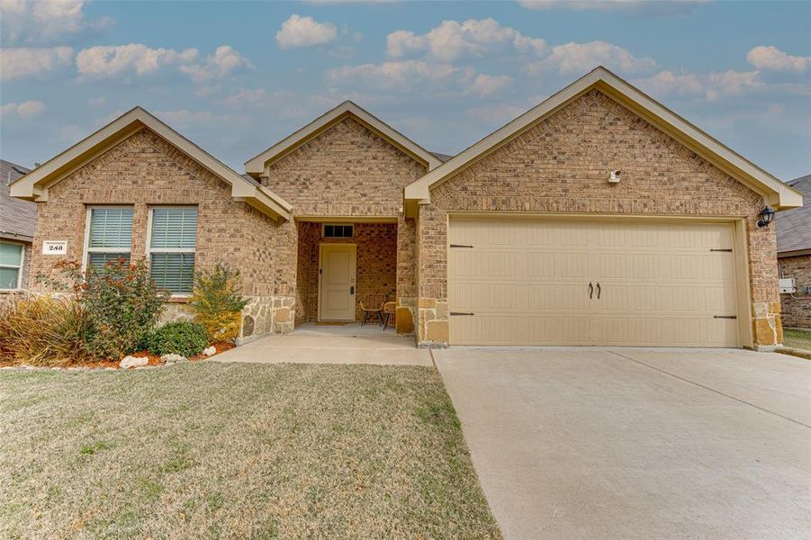 View of front facade featuring a front lawn and a garage