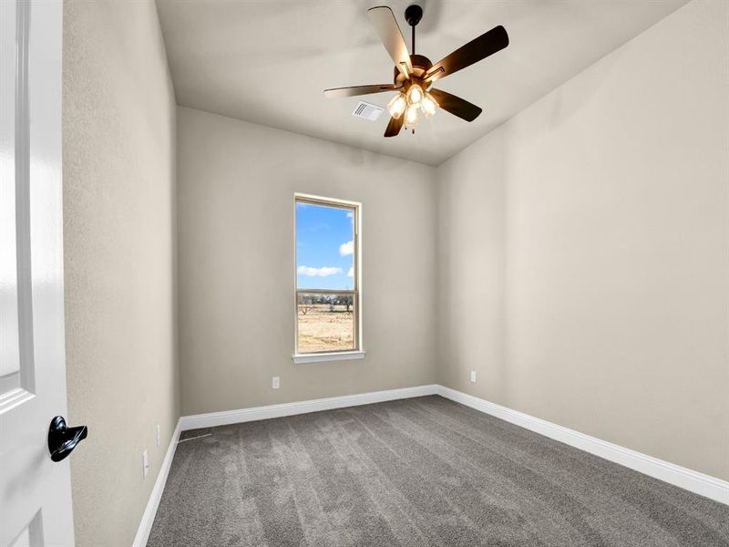 Empty room with carpet floors and ceiling fan