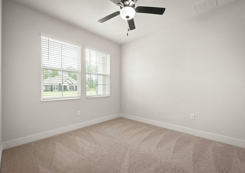 Secondary bedroom with carpet and fan.