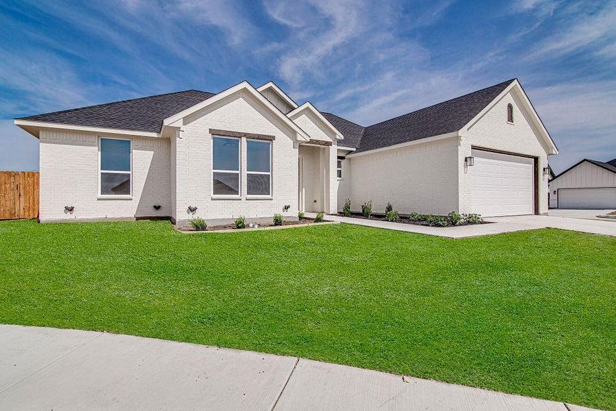 Single story home with a front yard, concrete driveway, fence, and brick siding