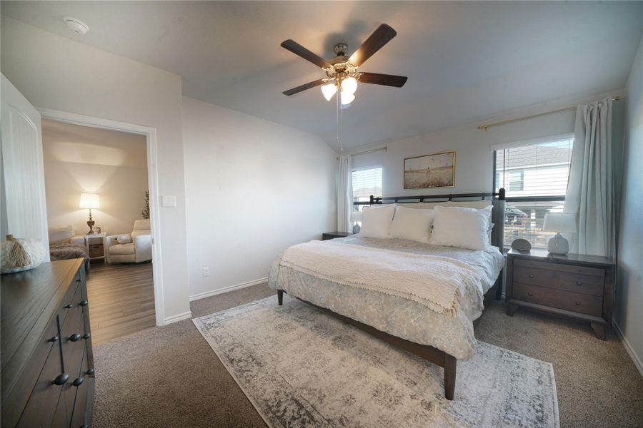 Bedroom featuring a ceiling fan, carpet, and lofted ceiling