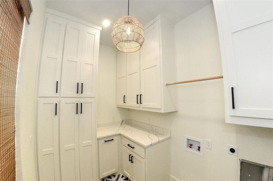 Laundry area full of cabinets and a laundry shoot hidden inside one.