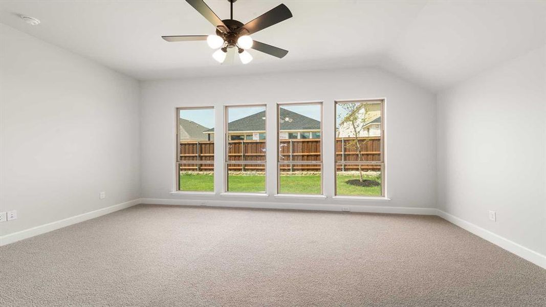 Unfurnished room with light carpet, a healthy amount of sunlight, and ceiling fan