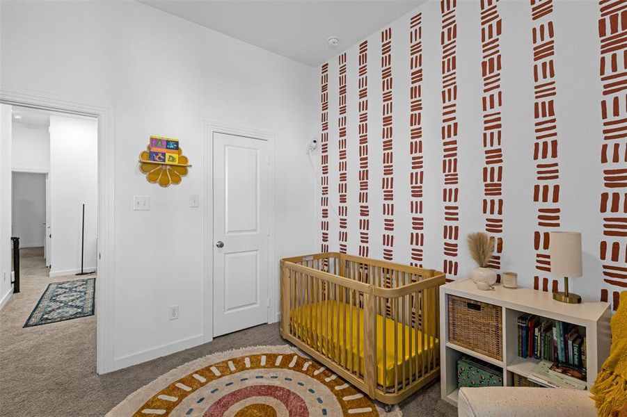 Bedroom with carpet floors and a crib