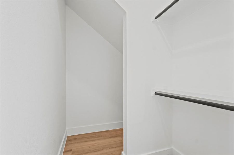 Spacious closet featuring light wood-style flooring