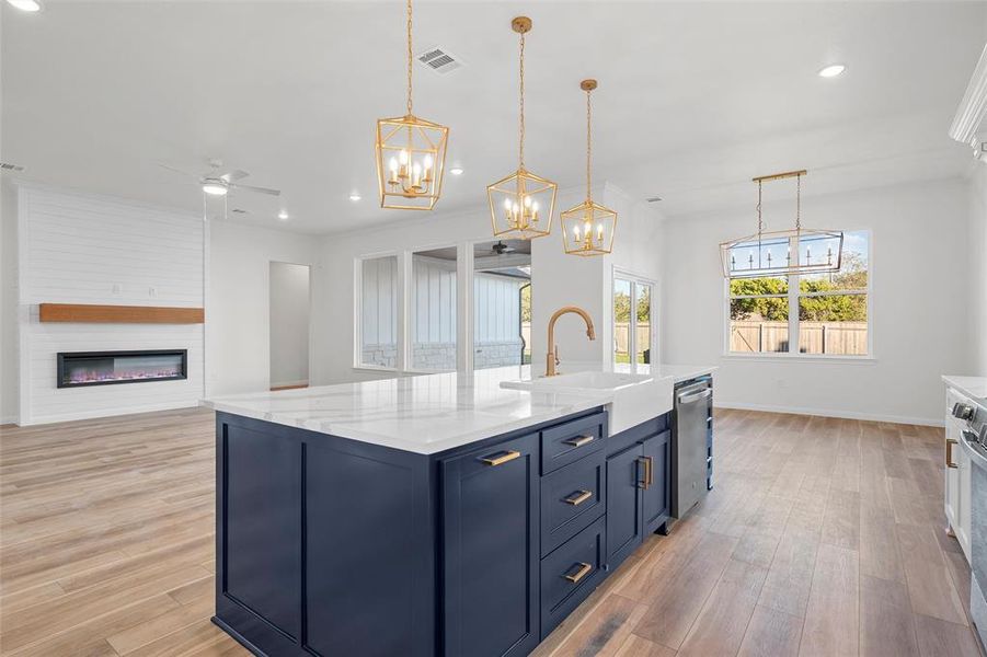 Kitchen featuring a ceiling fan, blue cabinets, open floor plan, decorative light fixtures, and recessed lighting