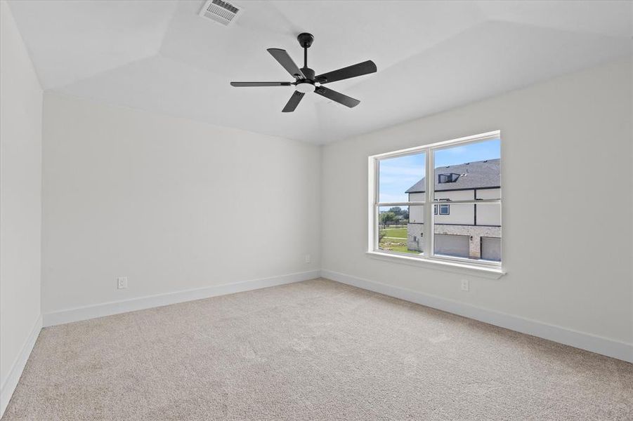 Carpeted empty room featuring baseboards and ceiling fan