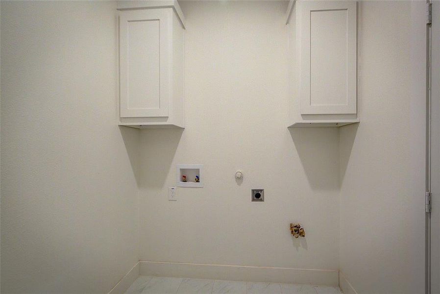 Washroom featuring hookup for a gas dryer, cabinet space, hookup for a washing machine, and hookup for an electric dryer Washroom featuring hookup for a gas dryer, cabinet space, hookup for a washing machine, and hookup for an electric dryer